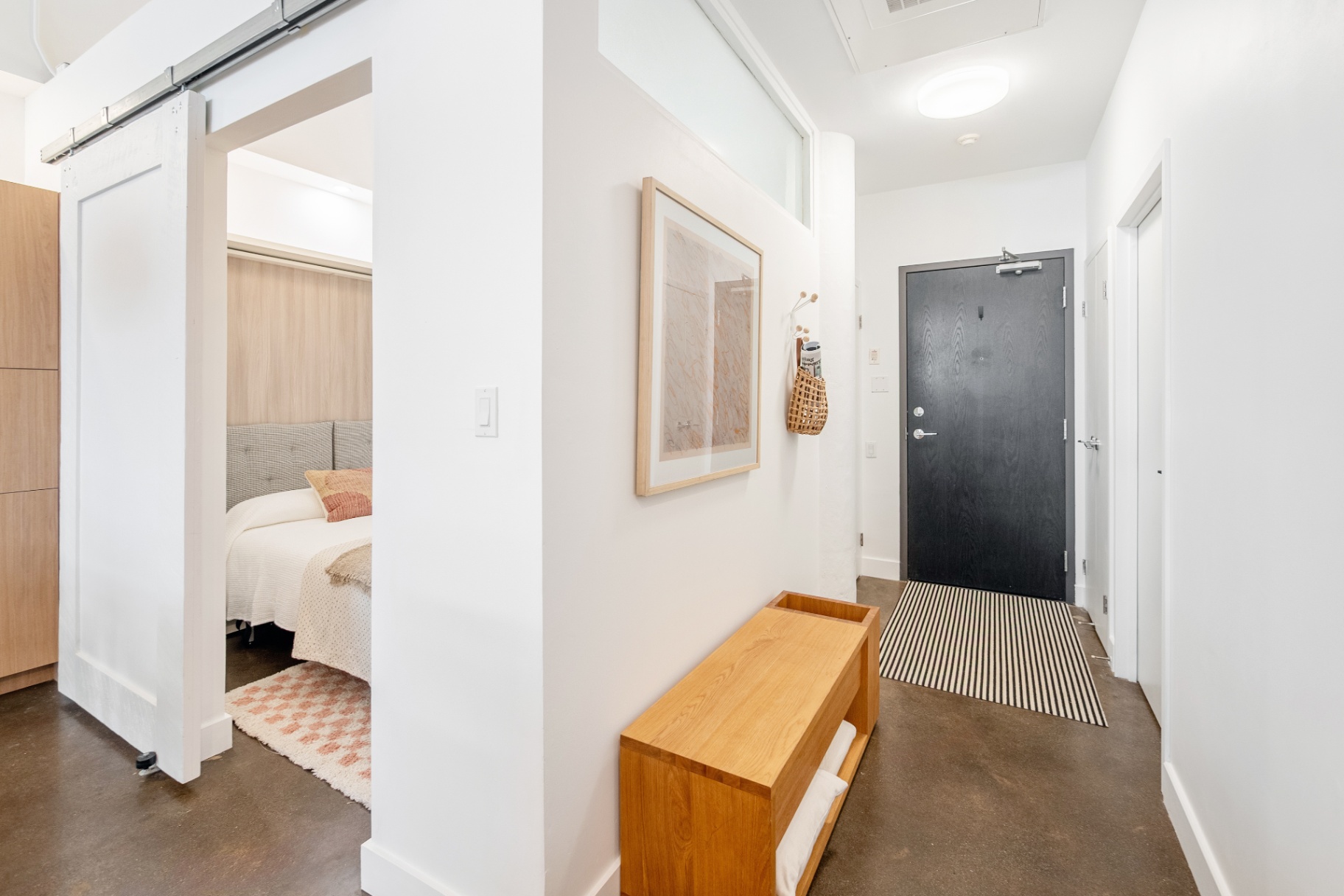 Entryway with bench and view to bedroom