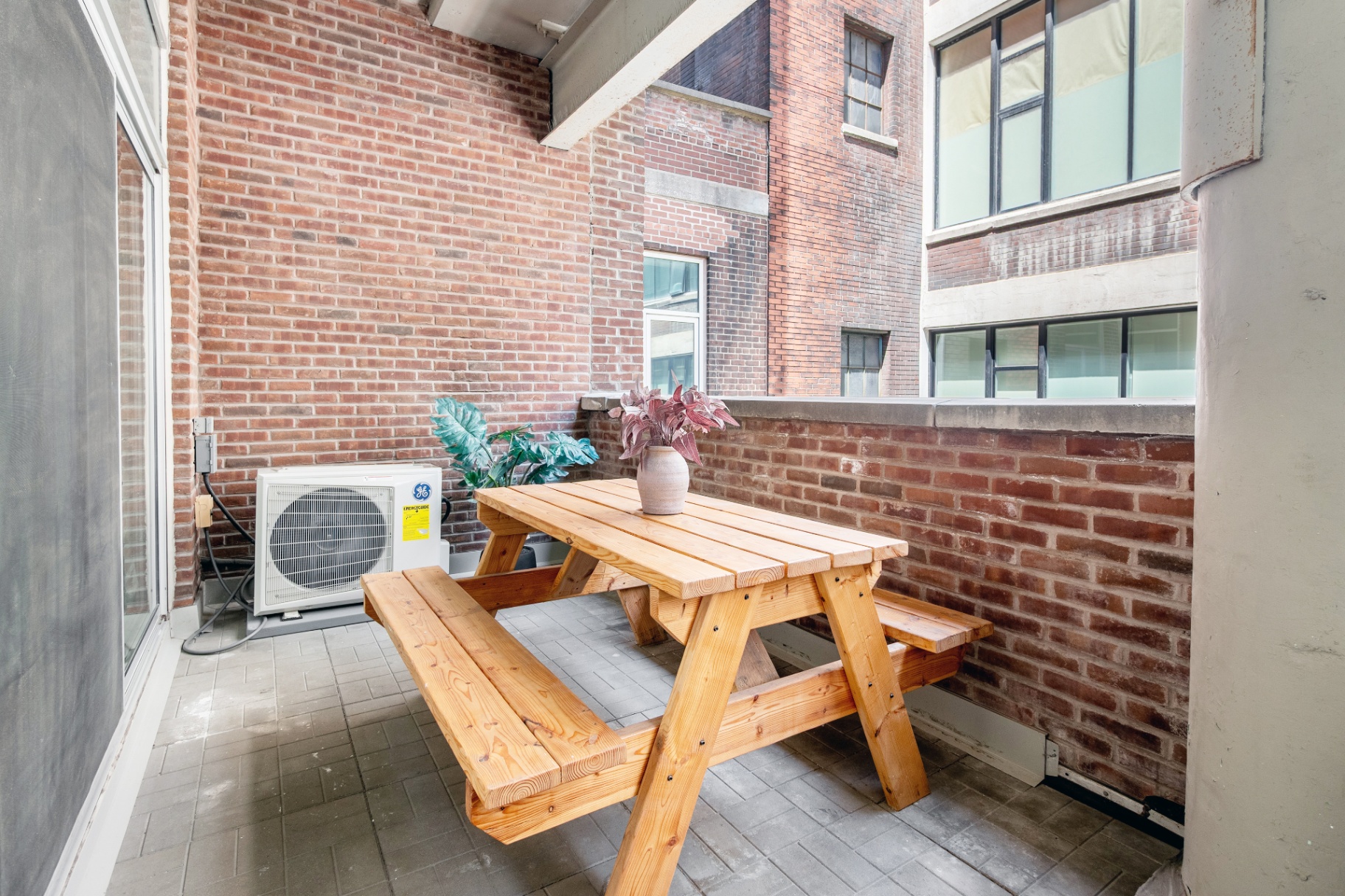 Terrace with picnic table against brick wall